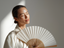 A woman cooling herself with a paper fan.