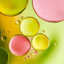 Colorful bubbles on a liquid surface with pink, yellow, and green hues.