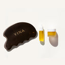 Bian stone gua Sha tool and a bottle of facial oil and recovery body treatment with 'YINA' branding on a white background